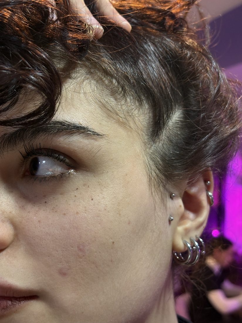 surface and anti tragus piercings, hand in curly hair