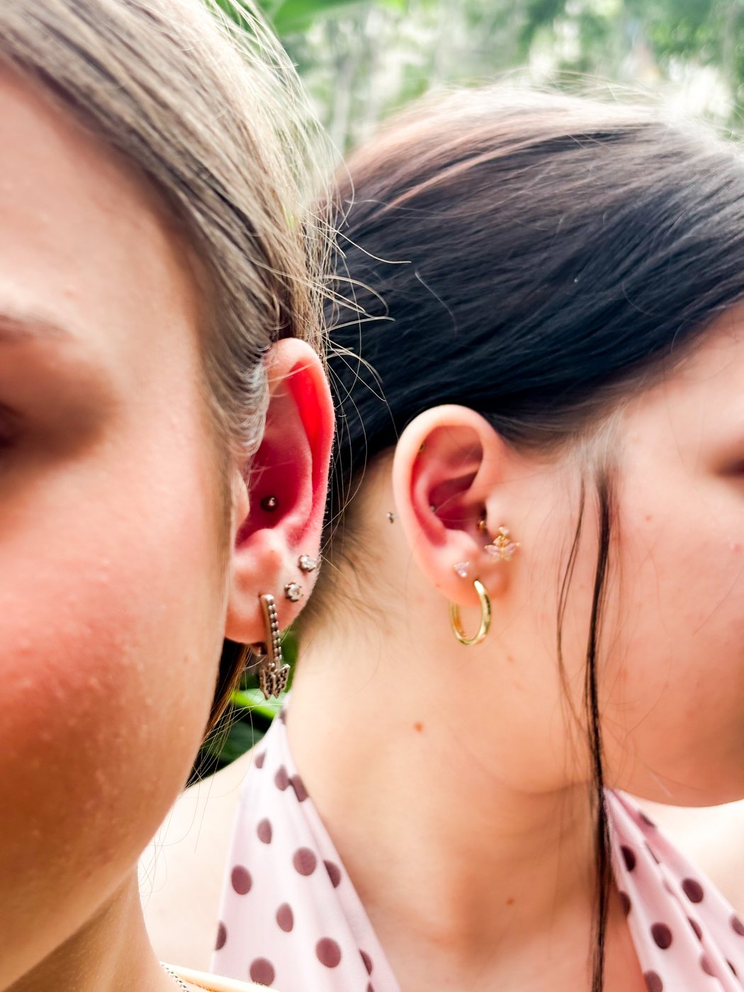 two friends' ears with helix and lobe jewelry