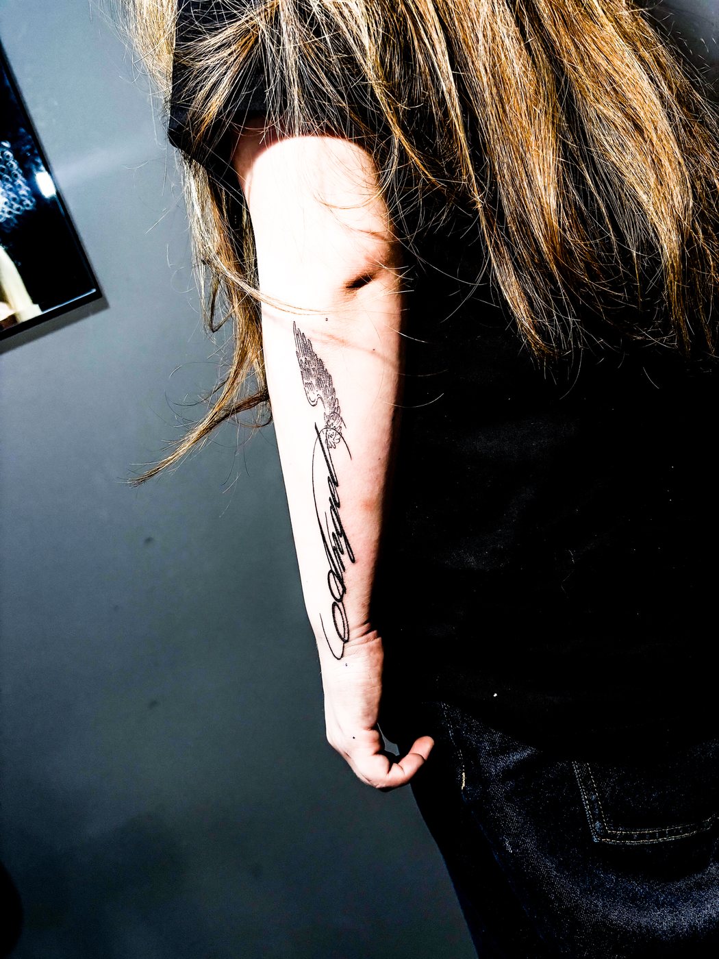 angel lettering forearm tattoo close-up